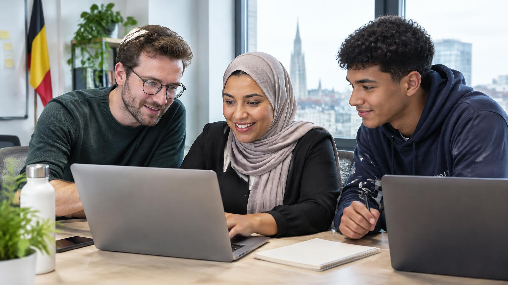Colleagues working together at laptops in a bright office
